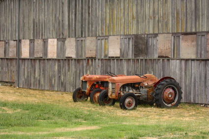 Two grey ferguson tractors left behind a shed